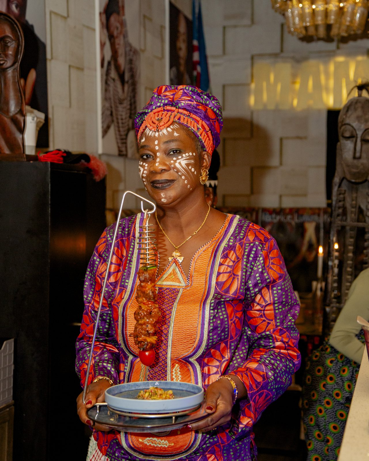 A host in traditional dress with ceremonial face paint
